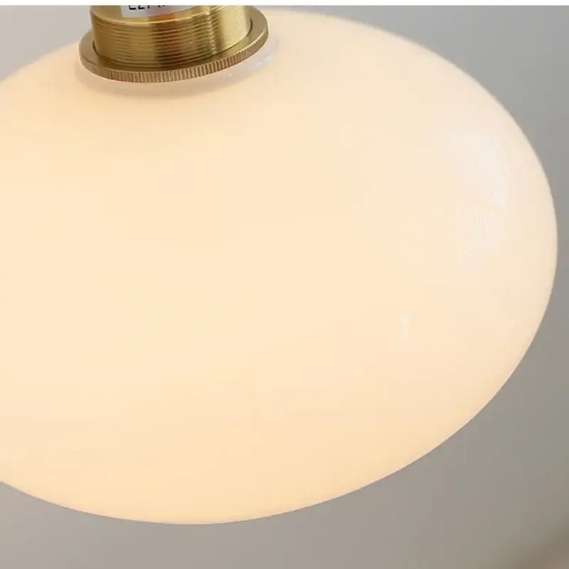 Cream-colored opal glass wall sconce with brass-finished metal fixture decorbites japanese style bedroom pull light