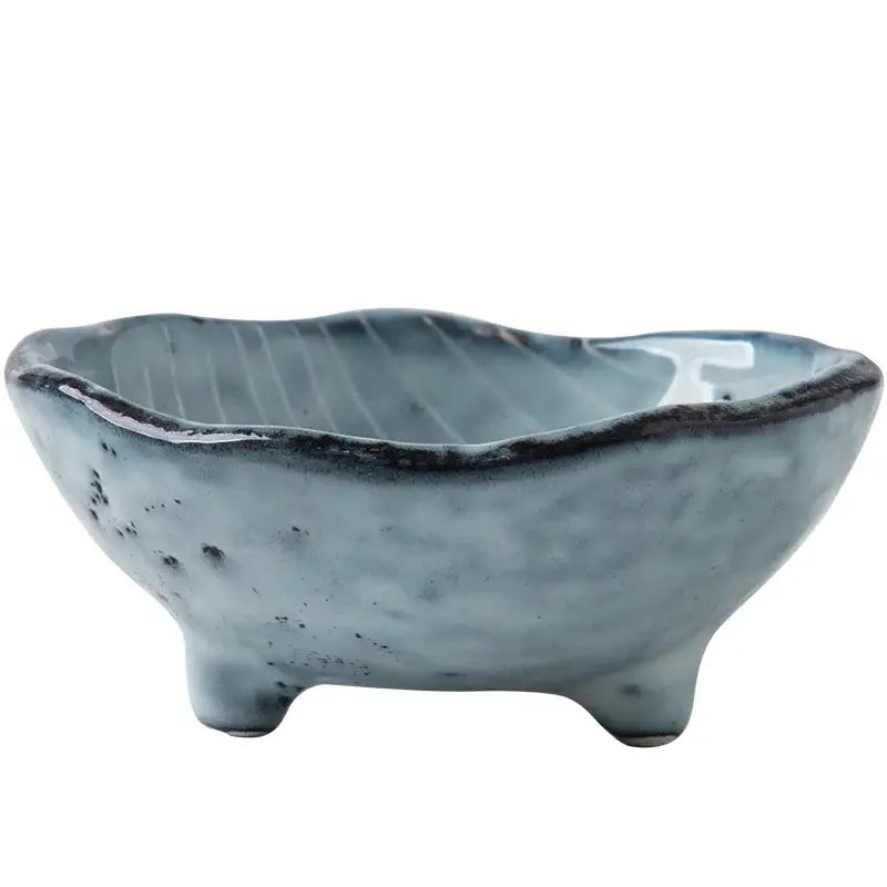 A rustic blue ceramic small sauce dish with textured speckled glaze and three short feet for dishes rice bowl use