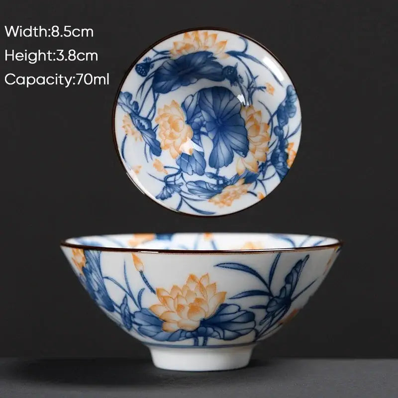 A delicate white ceramic kung fu tea cup with blue and orange lotus patterns and a thin brown rim by decorbites blue
