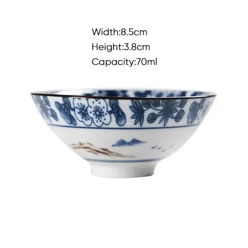 White ceramic kung fu tea bowl with intricate blue floral and mountain motifs in traditional decorbites blue design