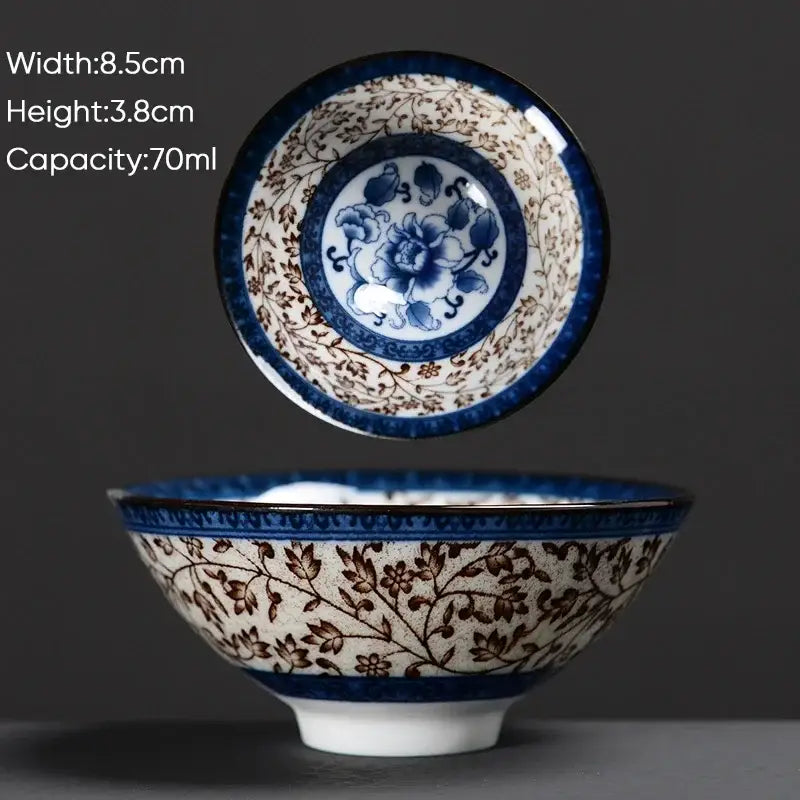 A delicate white ceramic kung fu tea cup with blue and brown floral patterns and bold navy-blue rims by decorbites blue