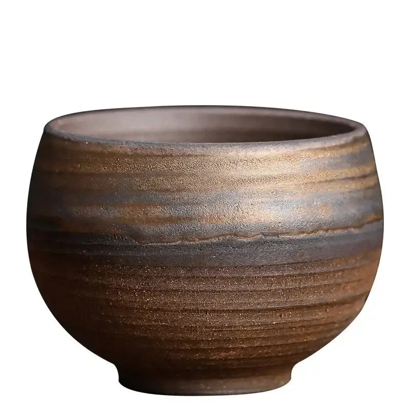 A rustic japanese style porcelain coffee tea cup with textured earthy brown glaze and horizontal ridges for dining use