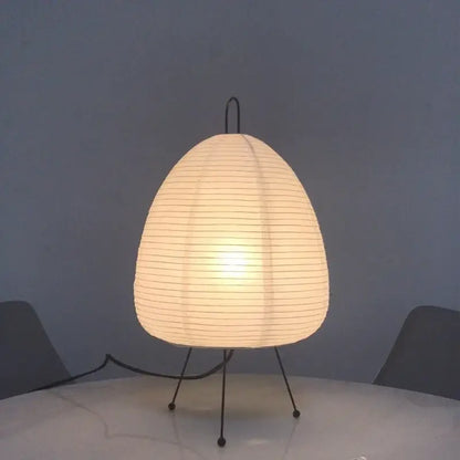 A warm white japanese style rice paper desk lamp with black metal tripod base ideal for bedroom lighting decorbites japanese style