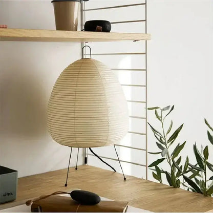 Beige japanese style rice paper table lamp with ribbed texture and black metal legs for minimalist bedroom decorbites table lamp