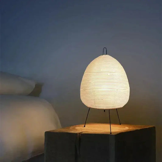 Warmly glowing japanese style rice paper table lamp with minimalist metal stand for bedroom decorbites japanese style