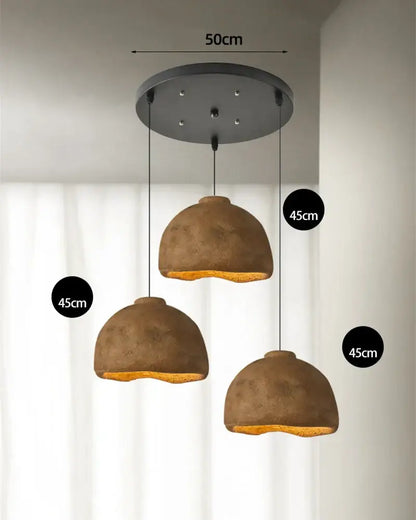 Set of three rustic brown resin pendant lights with matte finish and warm interior glow for dining room use