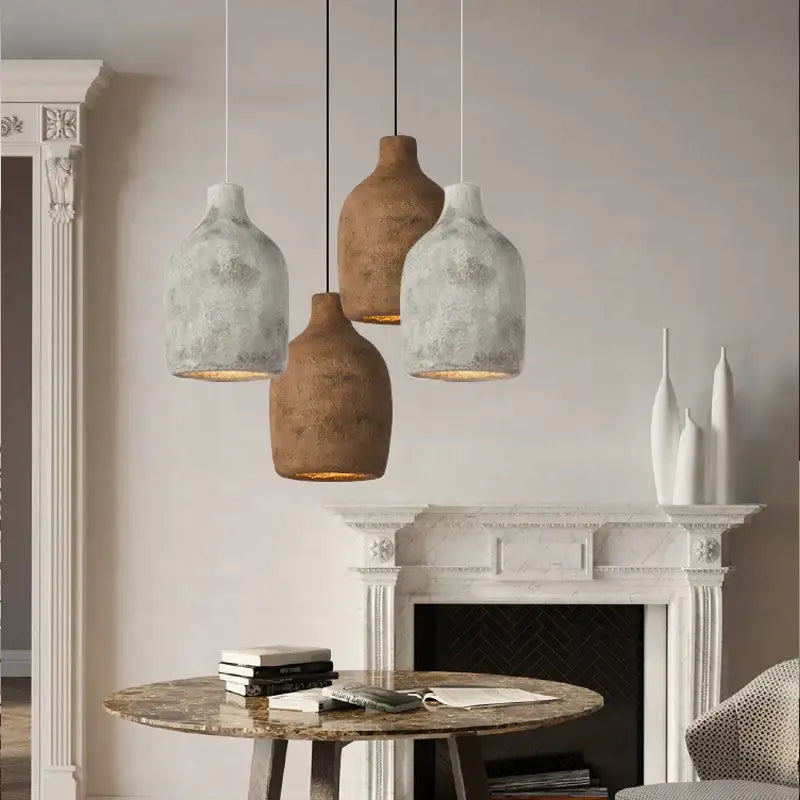Three rustic ceramic resin pendant lights with textured earthy tones hang from the ceiling for dining room use