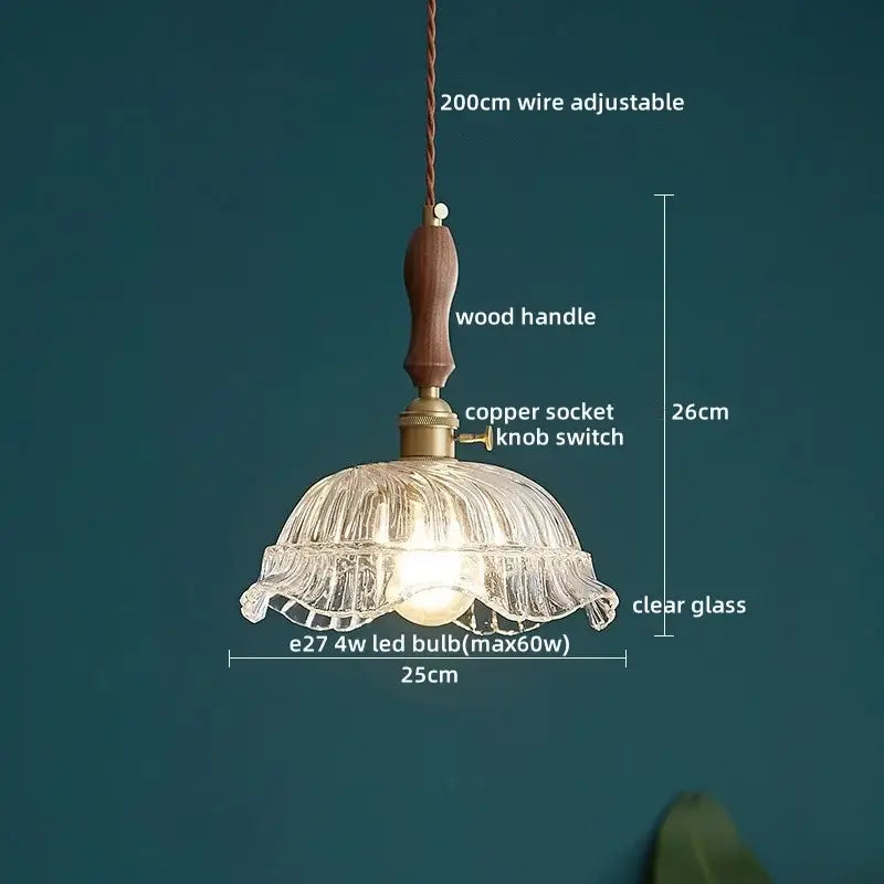 A delicate clear glass pendant lamp with ruffled petal design and warm wooden handle for dining room decorbites clear glass