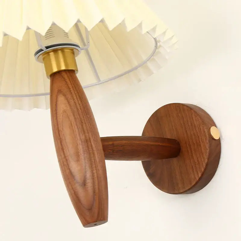 A warm-toned japanese walnut wood cream pvc led wall lamp with brass base and pleated cream pvc lampshade for bedroom decorbites cream pvc