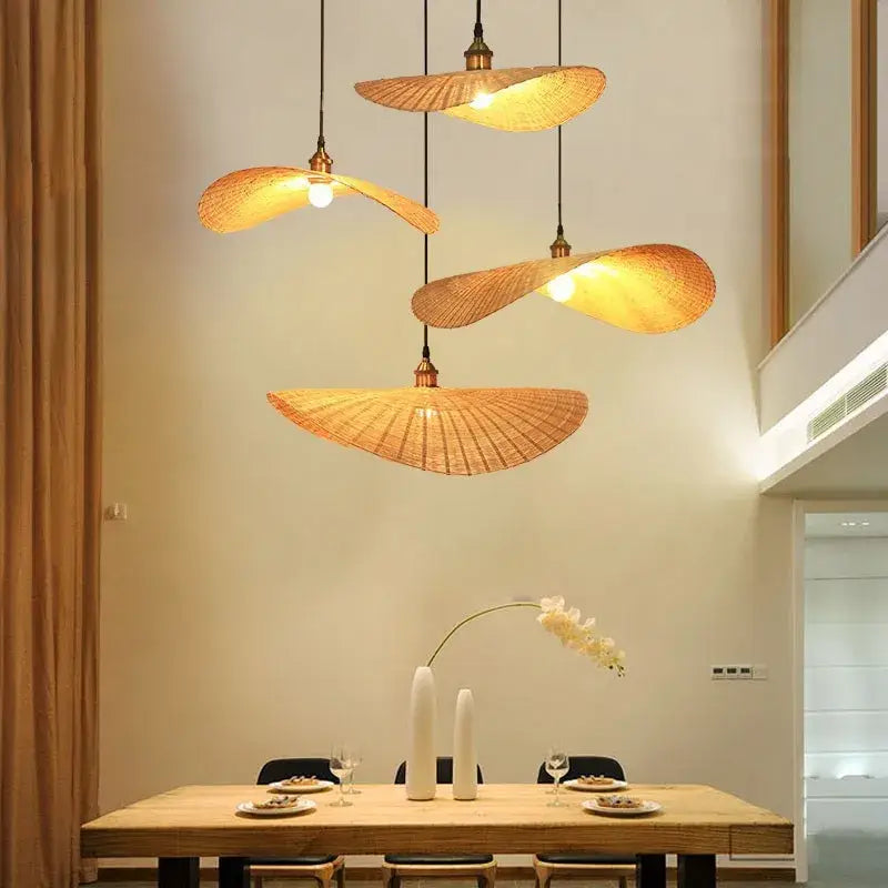 Four warm-toned fan-shaped pendant lights with woven natural fiber shades in a decorbites bamboo chandelier