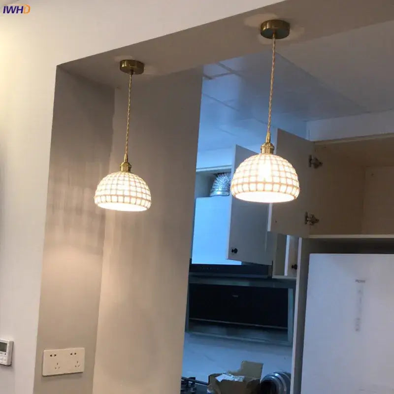 Two brass-finished pendant lights with spherical grid-patterned glass shades for dining room decorbites ceramic led