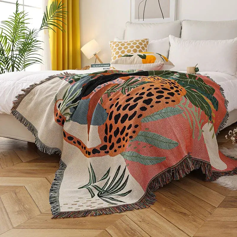 Vibrant jungle pink and cream leopard print throw blanket with bold orange leopard, green leaves, fringed edges decorbites leopard print