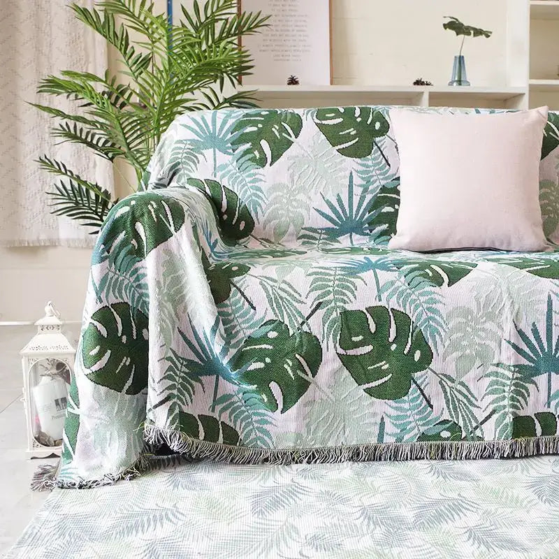 A cozy white sofa blanket with vibrant green and teal tropical leaf print and soft fringed edges perfect for decorbites leopard print throw decor