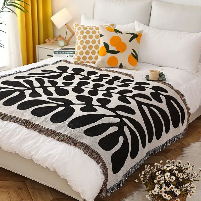Black and cream woven print throw blanket with bold leaf pattern and fringed edges perfect for decorbites leopard print decor