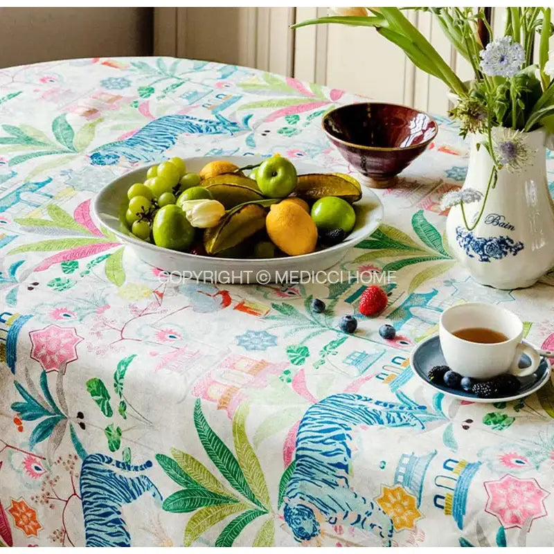 Jungle vibes tablecloth by decorbites featuring blue striped tigers and colorful botanical motifs on cream background