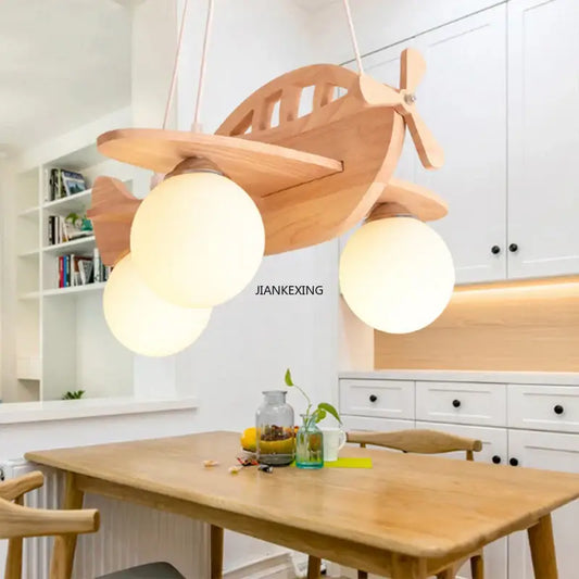 A light-colored wooden kids wood airplane pendant light with three frosted glass bulbs for bedroom decorbites kids wood