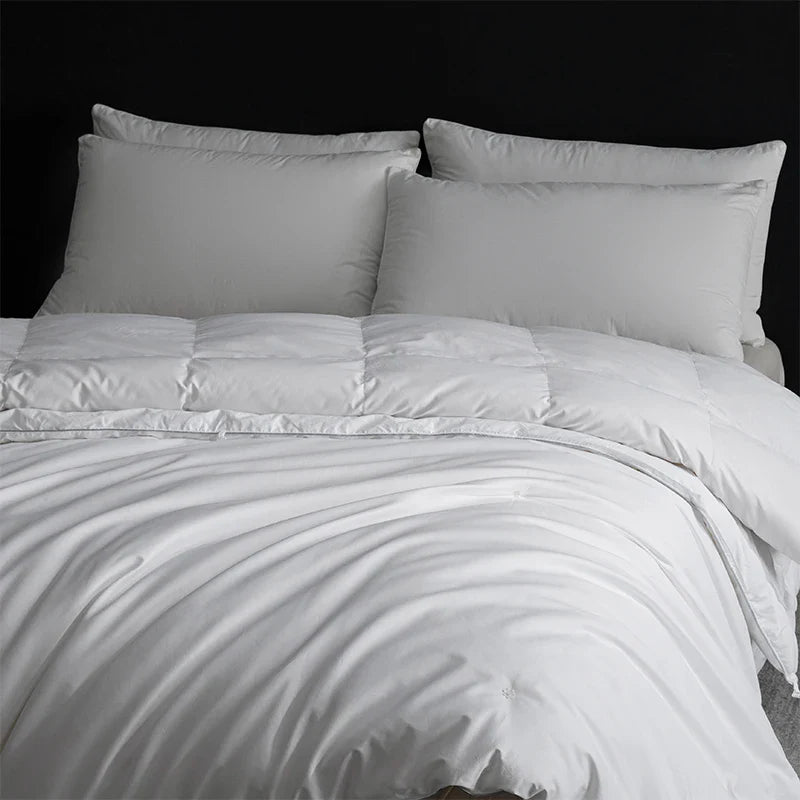 White quilted king size goose down and silk duvet set with smooth satin finish and matching pillows for luxury master bedroom