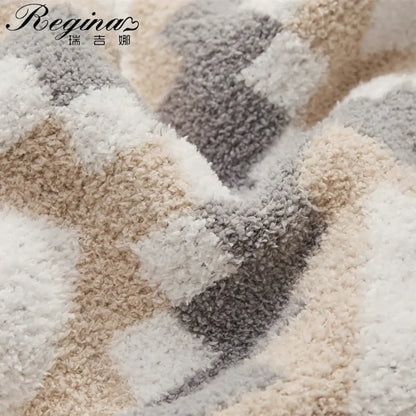 A cream and gray decorbites knitted geometric quilt blanket with a plush, textured, and fluffy surface
