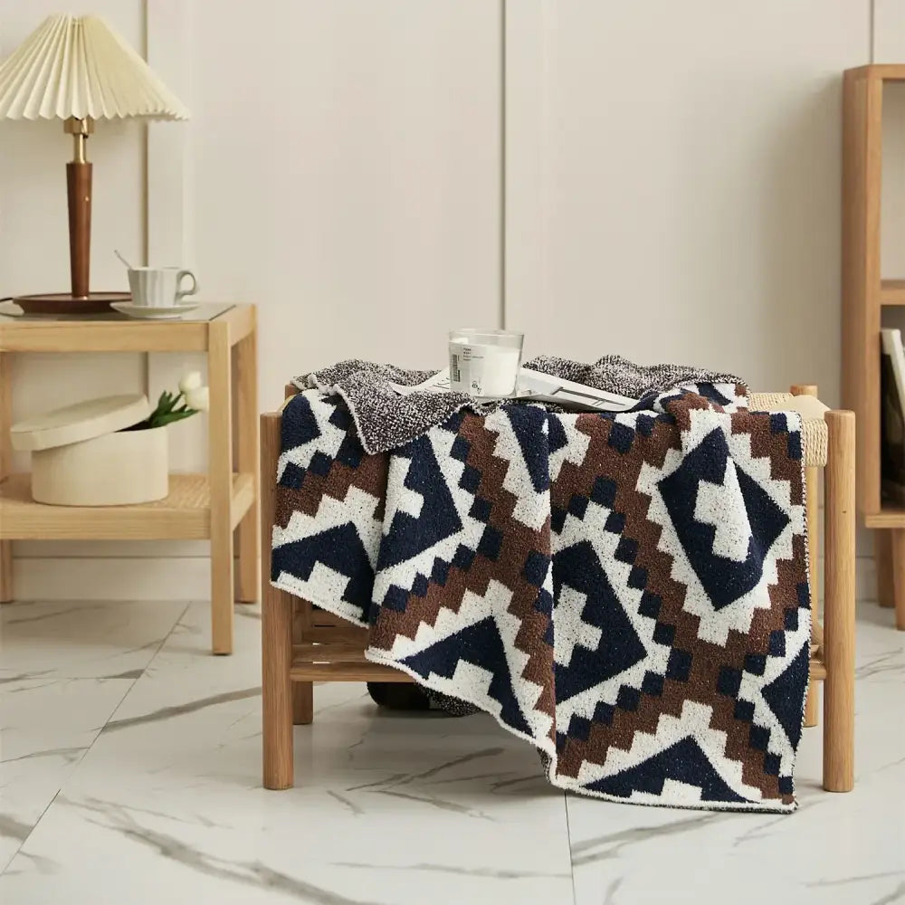 A cozy decorbites knitted geometric quilt blanket with navy blue brown and white bold pattern for living room decor