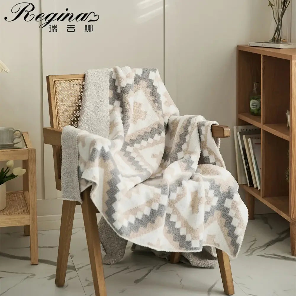Soft cream and gray knitted geometric quilt blanket terry cloth throw draped over wooden chair decorbites knitted geometric