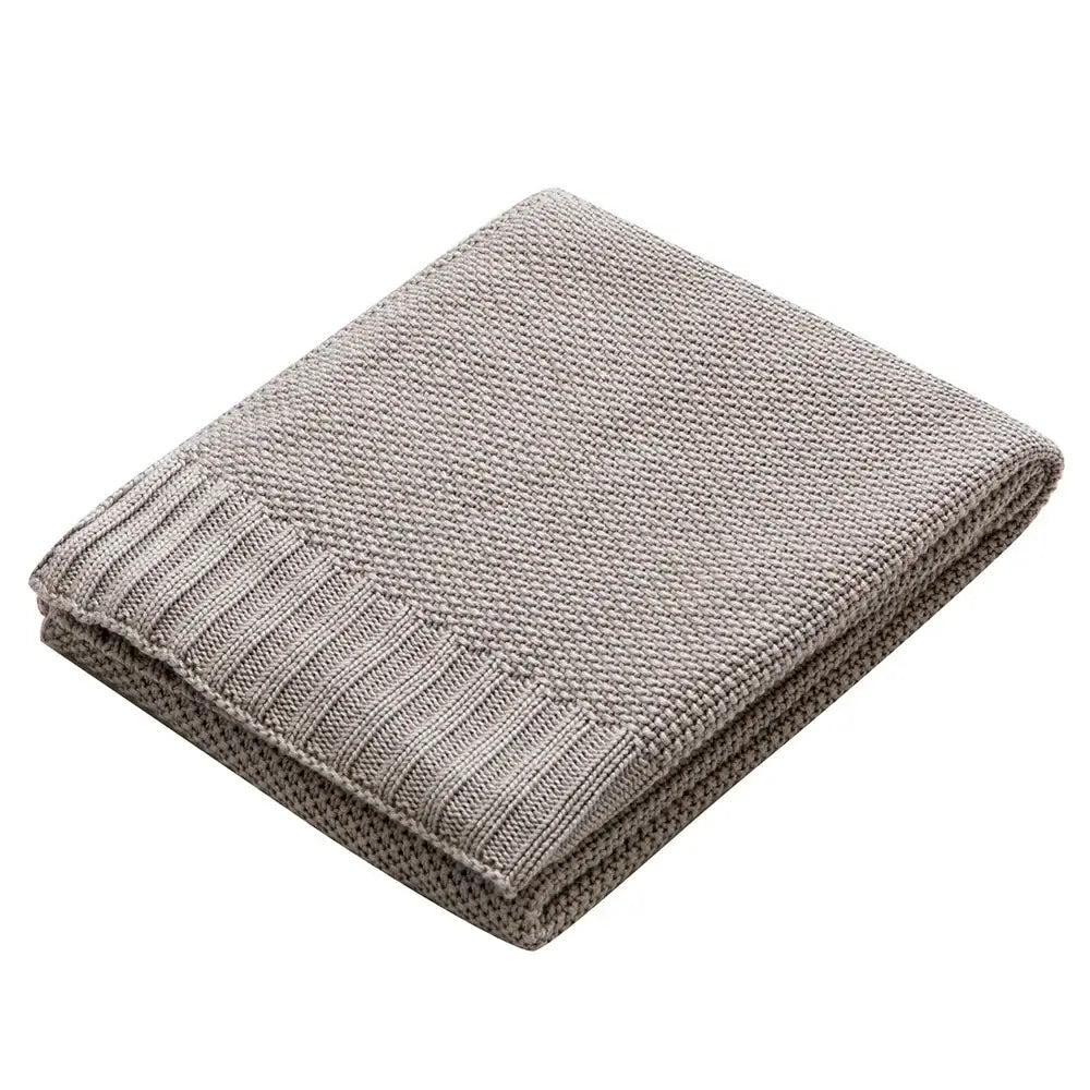 A soft light gray knitted bamboo baby blanket with textured weave and ribbed edge for nursery use