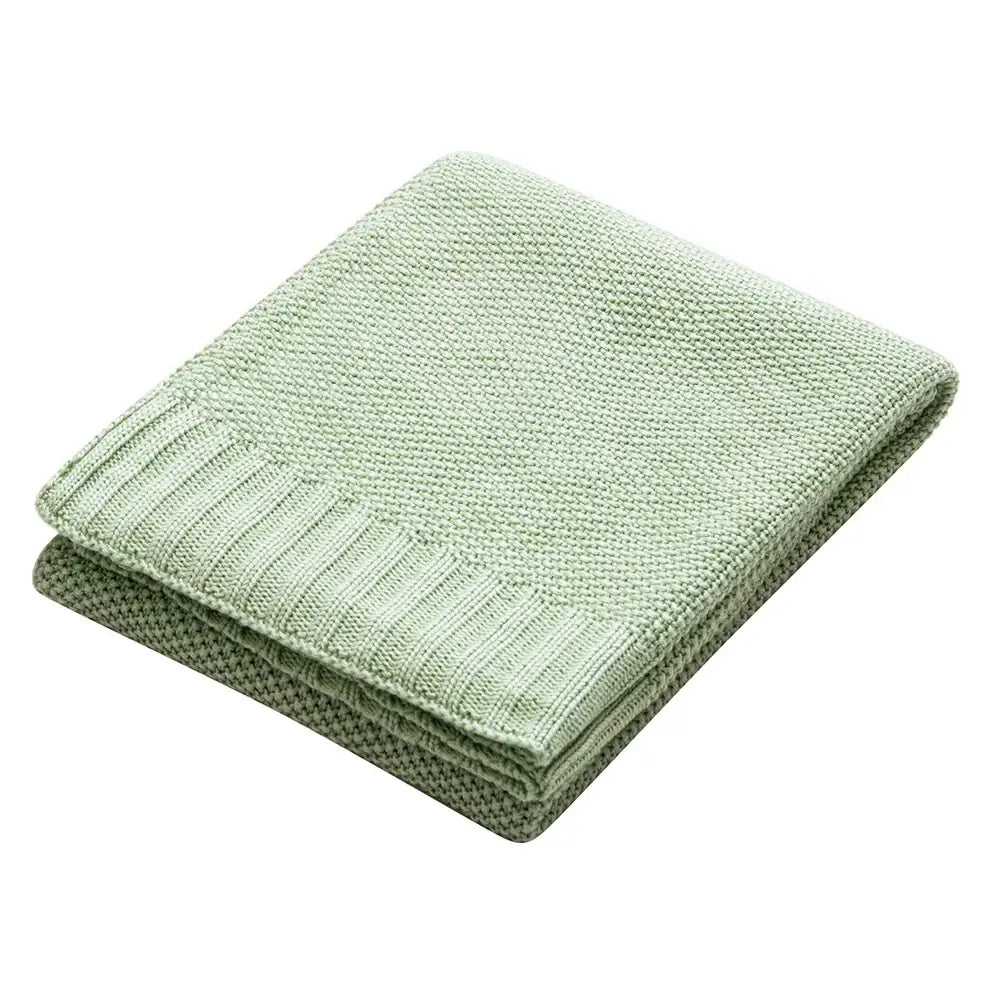A soft light green knitted bamboo baby blanket with textured weave and ribbed edge for nursery use