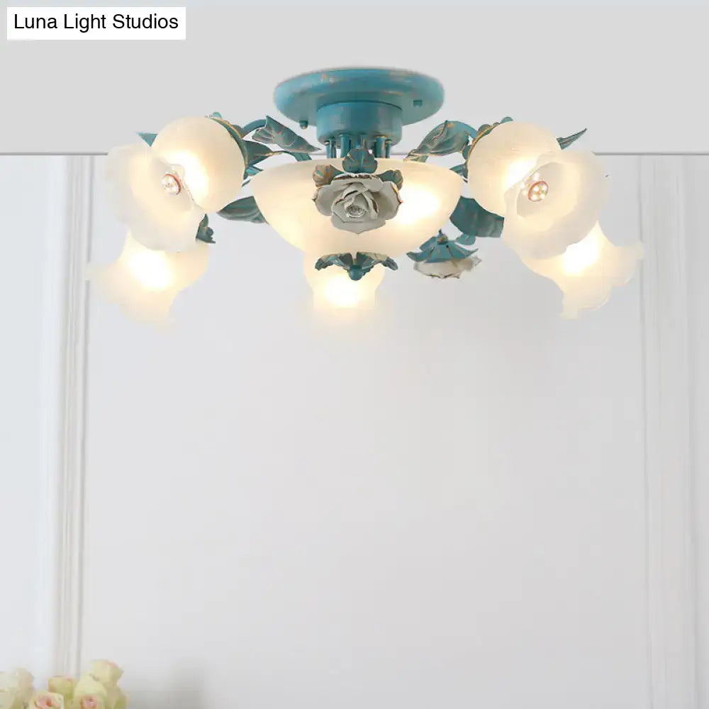 A teal metal ceiling mounted light with frosted glass korean garden flower shades and a central rose design