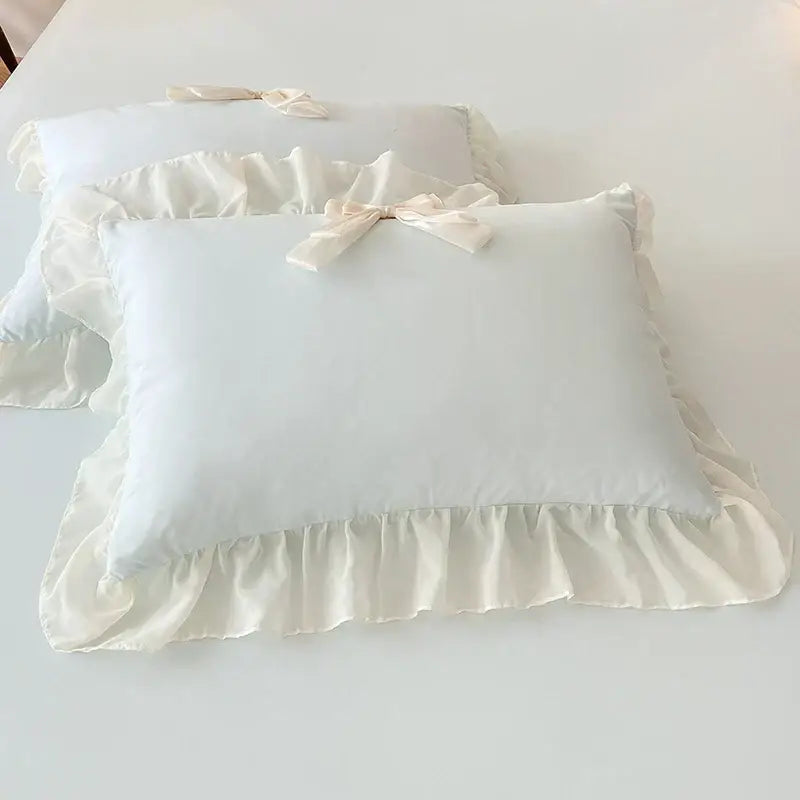 Cream-colored satin pillowcases with delicate ruffled edges and korean lace bow in decorbites korean lace bedding set