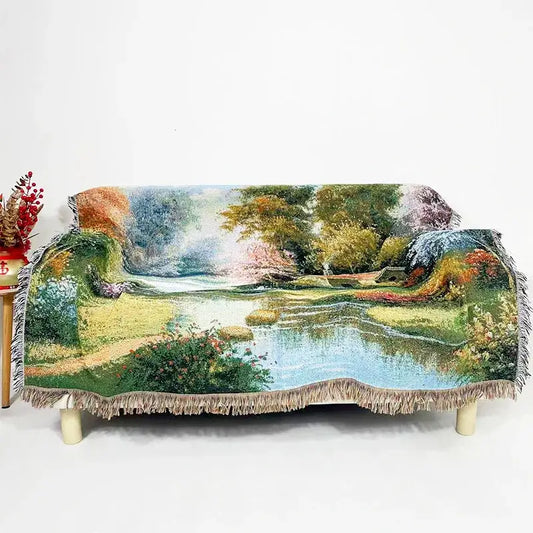 A decorbites jacquard sofa blanket featuring a vibrant landscape scene with fringed edges in rich earthy tones