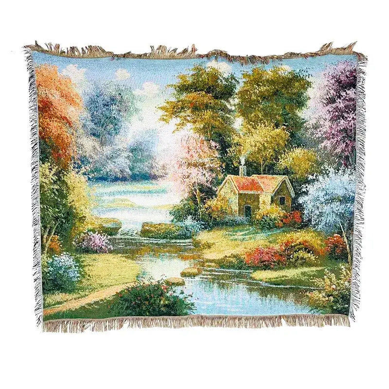 A decorbites jacquard sofa blanket with a woven landscape tapestry featuring autumn trees and a yellow house