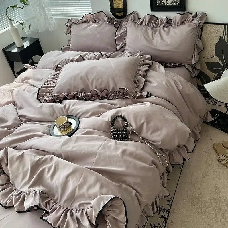 A plush mauve velvet bedding set with black trim and ruffled edges from decorbites cooling silky ruffled collection