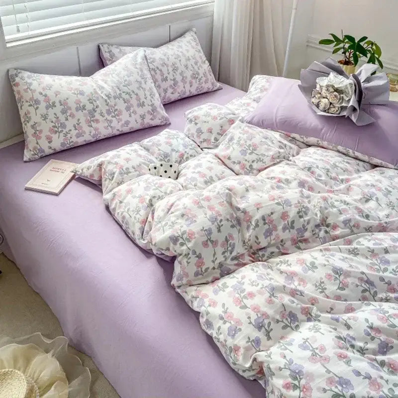 A soft lavender bed sheet set with double layer yarn and pastel pink floral pattern for a cozy bedroom