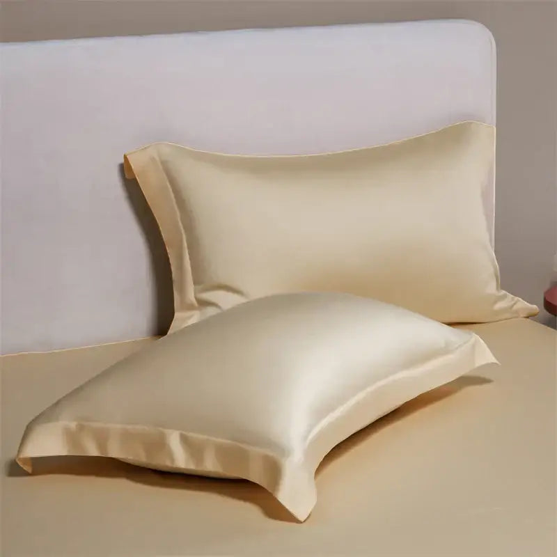 Cream-colored satin egyptian cotton pillowcases with a smooth glossy finish in a cotton pillowcase set for bedroom bedding