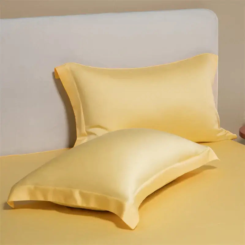 Pair of pale yellow satin egyptian cotton pillowcases with a smooth glossy finish in a cotton pillowcase set