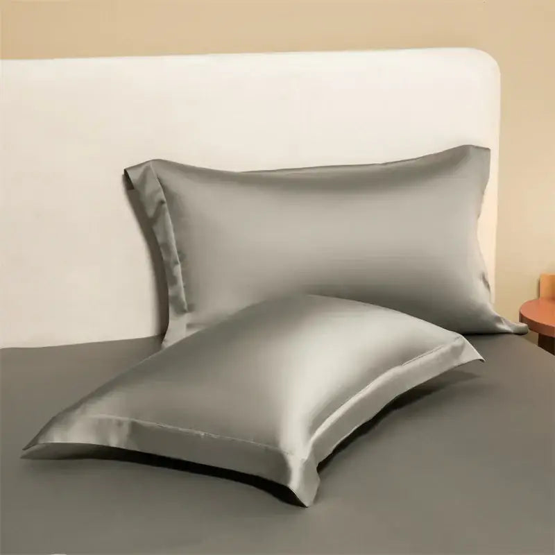 Two sleek silver-gray satin egyptian cotton pillowcases from a lavender cotton pillowcase set for bedroom bedding covers