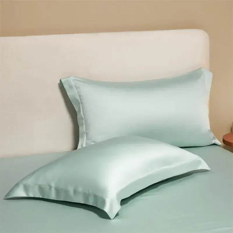 Two mint green satin pillowcases with a smooth finish from a lavender egyptian cotton pillowcase set for bedroom bedding covers
