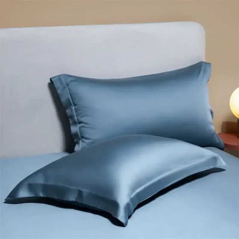 Two elegant slate-blue egyptian cotton pillowcases with a smooth lustrous finish in a cotton pillowcase set