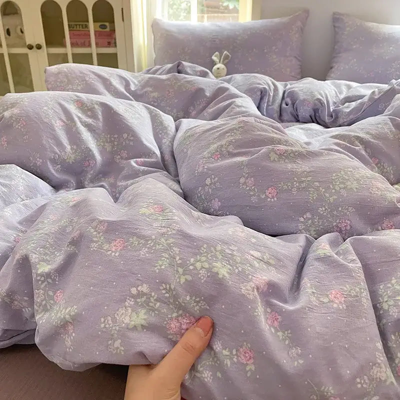 Soft lavender cotton bedding set with delicate pink and pale green floral pattern and subtle textured weave