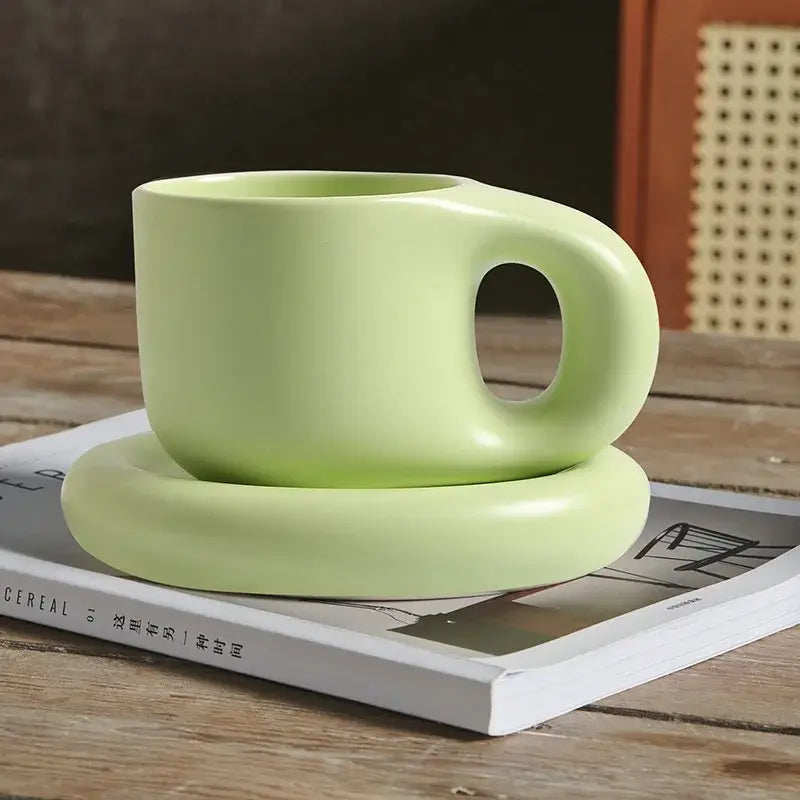 Pastel green ink splash ceramic mug with rounded minimalist handle and matching oval plate from decorbites ink splash set
