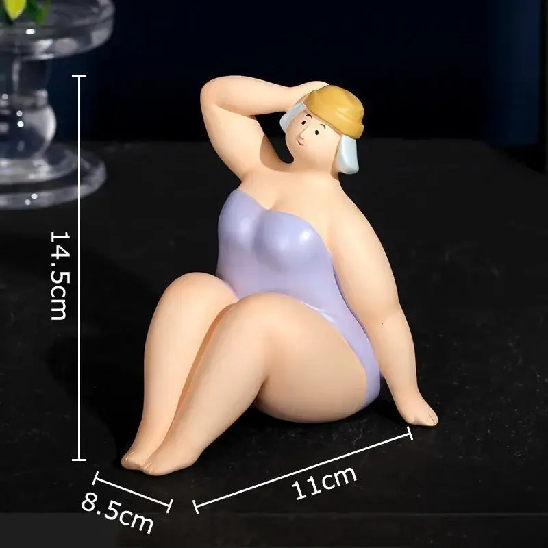 A lavender and pink swimsuit women resin figurine wearing a yellow and white swim cap sitting on heels for decor
