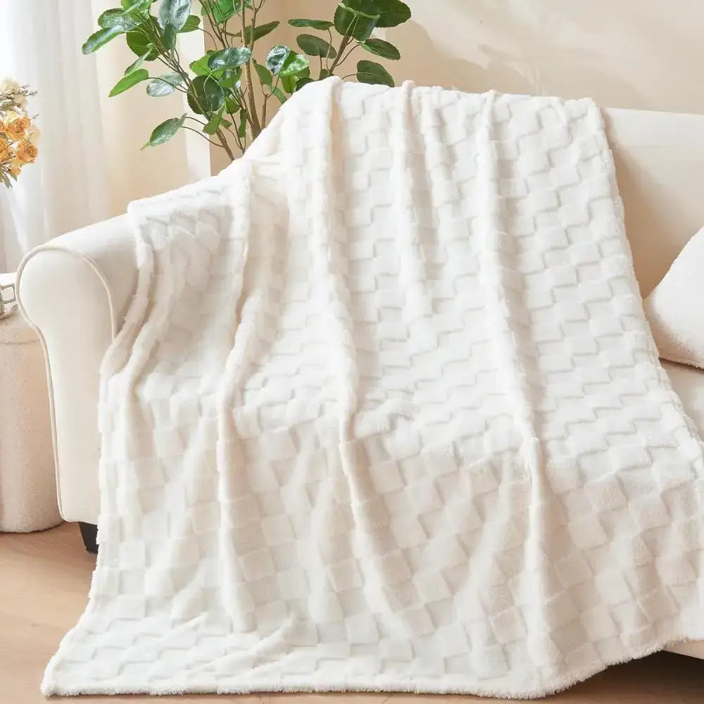 A decorbites cozy fluffy white plush blanket with a textured woven pattern draped over a sofa for living room decor
