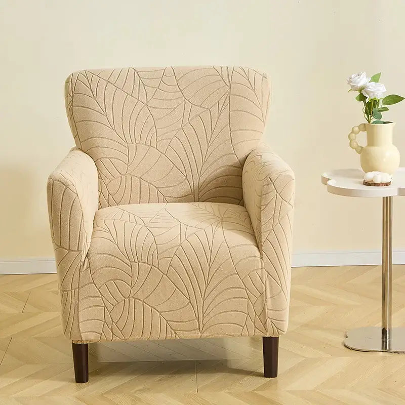 Beige leaf pattern jacquard elastic chair cover with textured fabric and dark wooden legs for dining room chairs