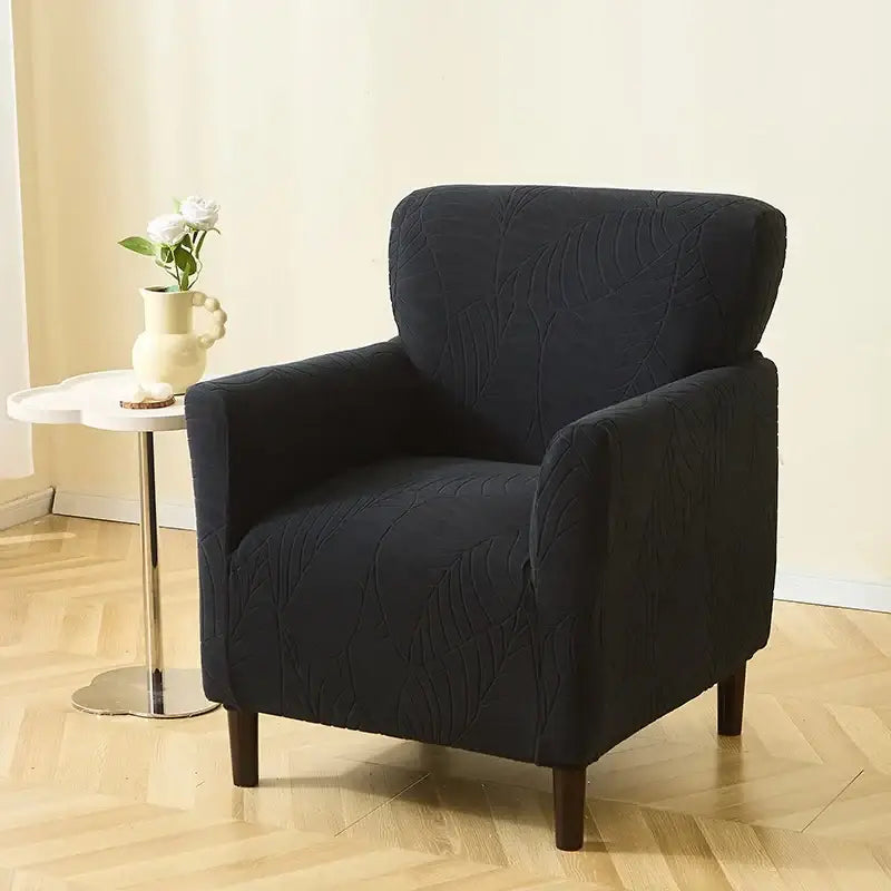 Black upholstered armchair featuring a subtle leaf pattern jacquard elastic slipcover for dining room use