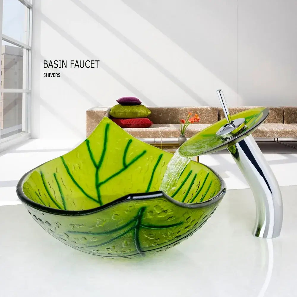 Vibrant green glass vessel sink shaped like a leaf with embossed veins and black rim paired with chrome faucet