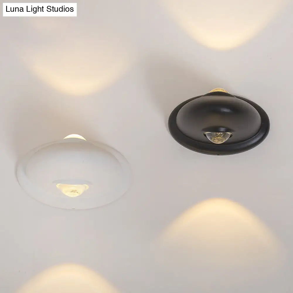 Aplique de pared LED DecorBites™ para dormitorio con pantalla triangular contemporánea de aluminio y acabado en blanco y negro con iluminación blanca cálida.