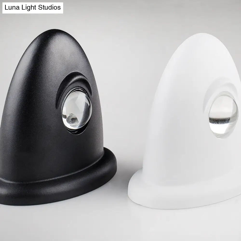 Aplique de pared LED DecorBites™ para dormitorio con pantalla triangular contemporánea de aluminio y acabado en blanco y negro con iluminación blanca cálida.