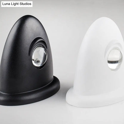 Aplique de pared LED DecorBites™ para dormitorio con pantalla triangular contemporánea de aluminio y acabado en blanco y negro con iluminación blanca cálida.