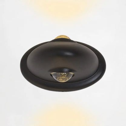 Aplique de pared LED DecorBites™ para dormitorio con pantalla triangular contemporánea de aluminio y acabado en blanco y negro con iluminación blanca cálida.