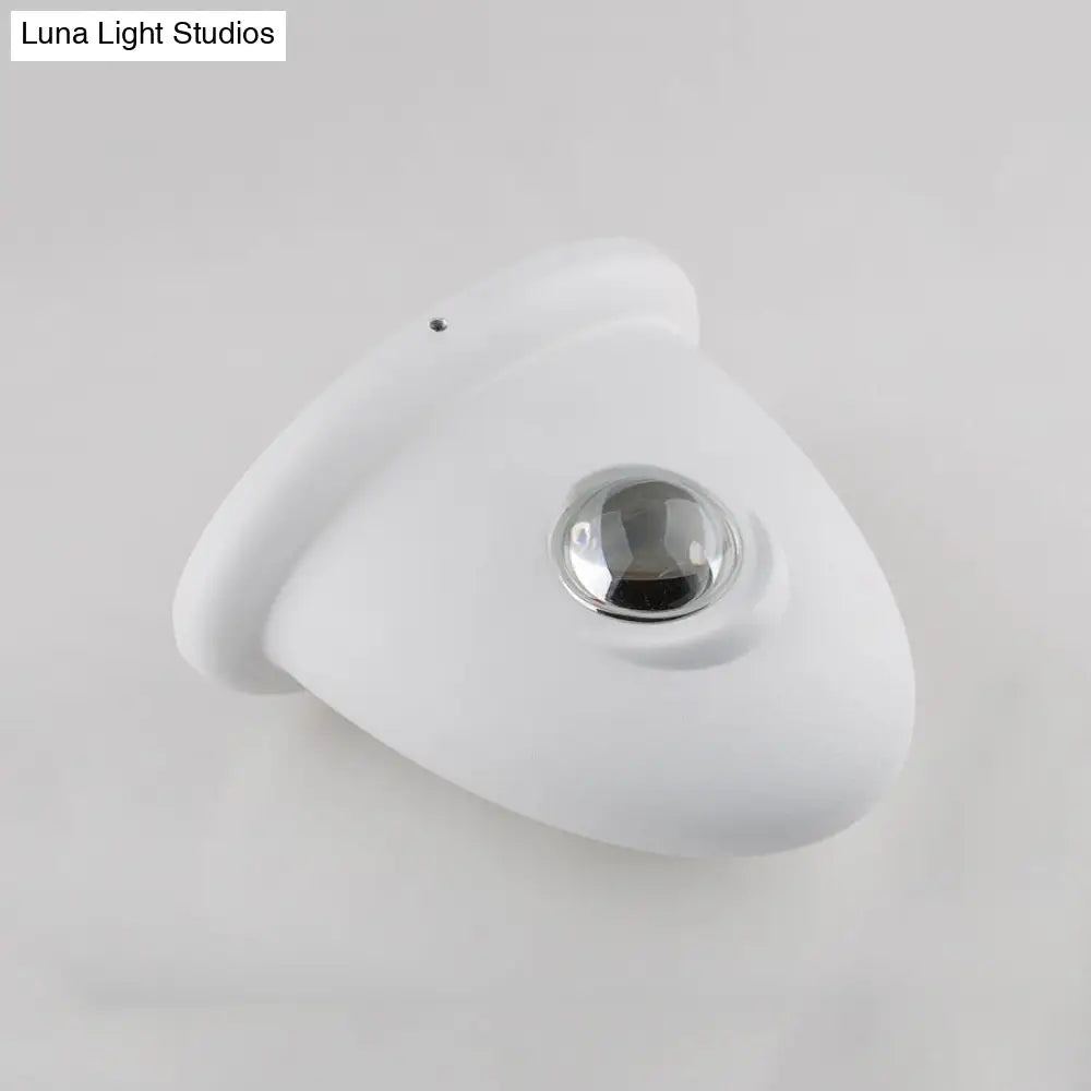 Aplique de pared LED DecorBites™ para dormitorio con pantalla triangular contemporánea de aluminio y acabado en blanco y negro con iluminación blanca cálida.