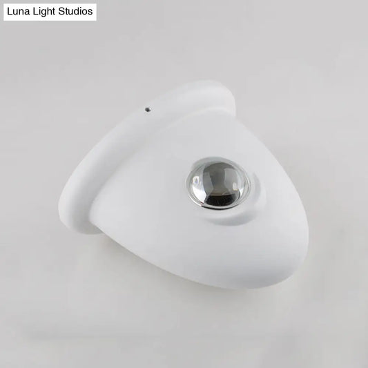 Aplique de pared LED DecorBites™ para dormitorio con pantalla triangular contemporánea de aluminio y acabado en blanco y negro con iluminación blanca cálida.